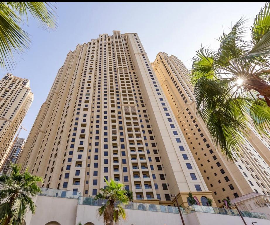 a tall building with palm trees in front of it at JBR Jumeirah beach SADAF6 sea view in Dubai