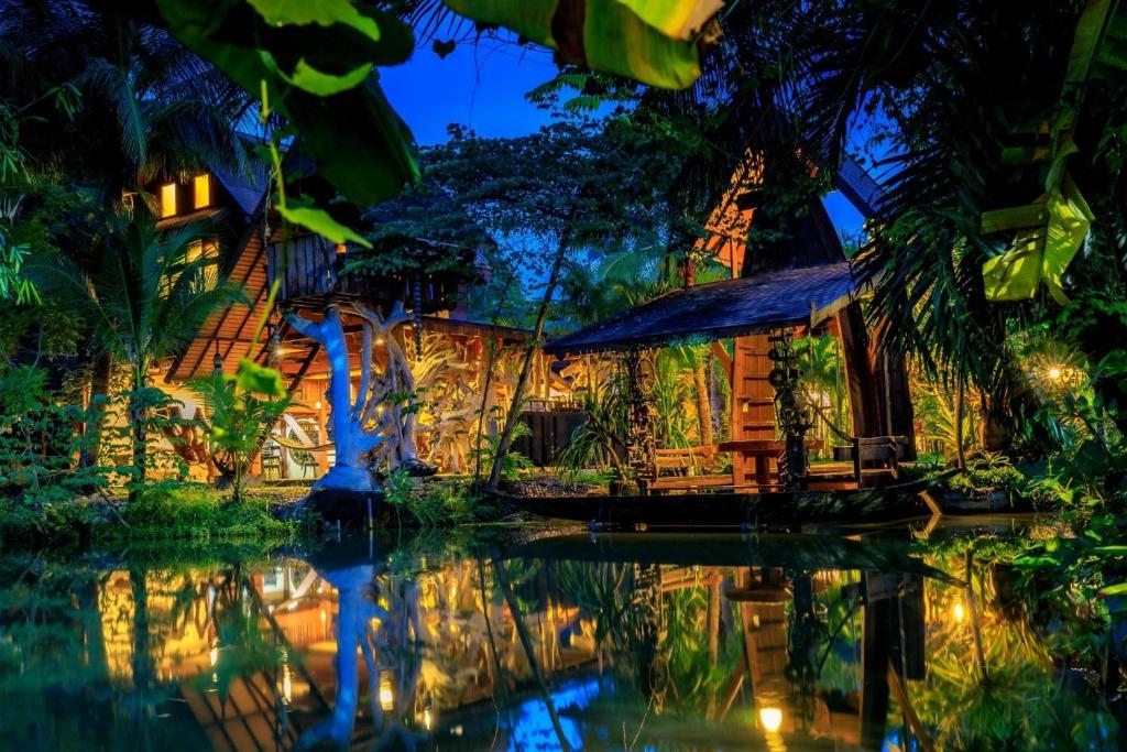 uma casa na selva à noite em Suankaew Art Cottage em Ban Tha Sai