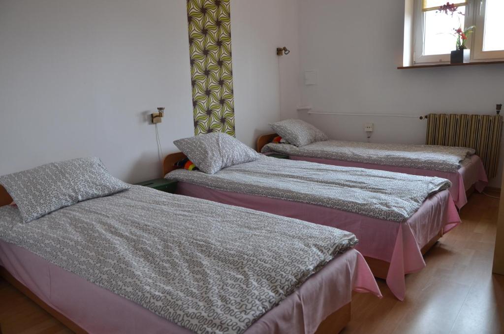 ワルシャワにあるApartament Tolekのベッド3台が備わる部屋