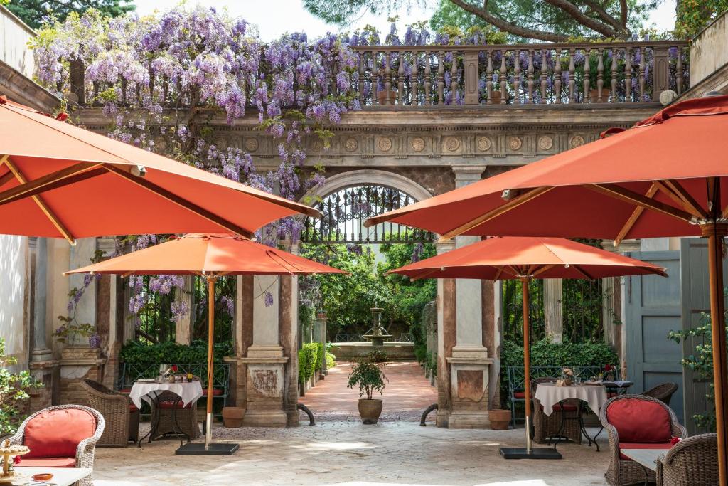 an outdoor patio with tables and umbrellas at Palazzo Margherita in Bernalda