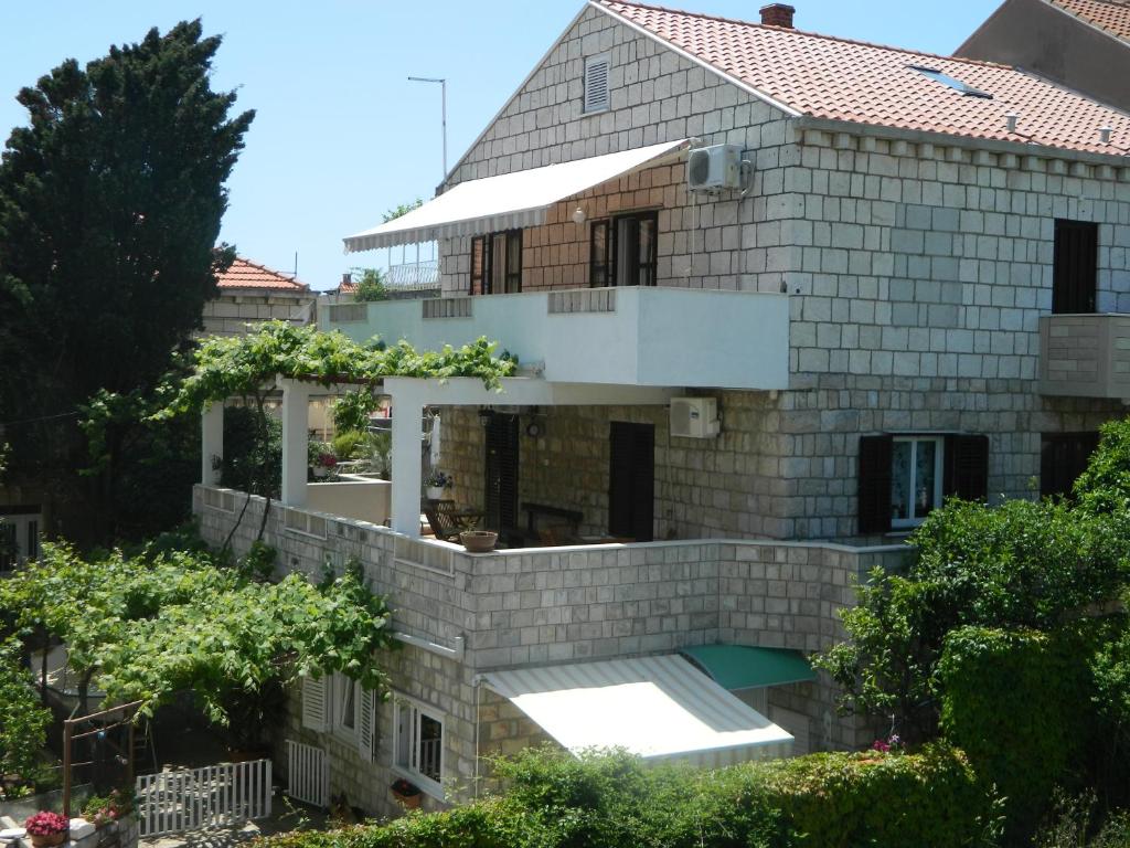 a house with a pool in front of it at Apartments BrunoR in Dubrovnik