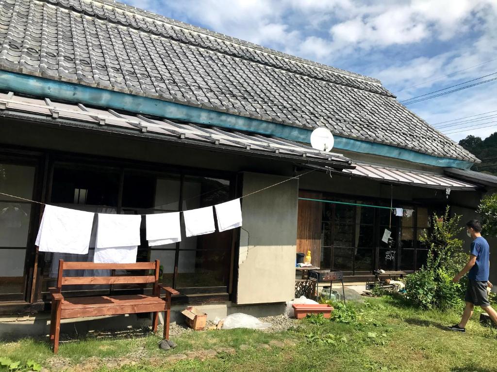 a man walking in front of a house at Guest House Yukari in Tsuru 