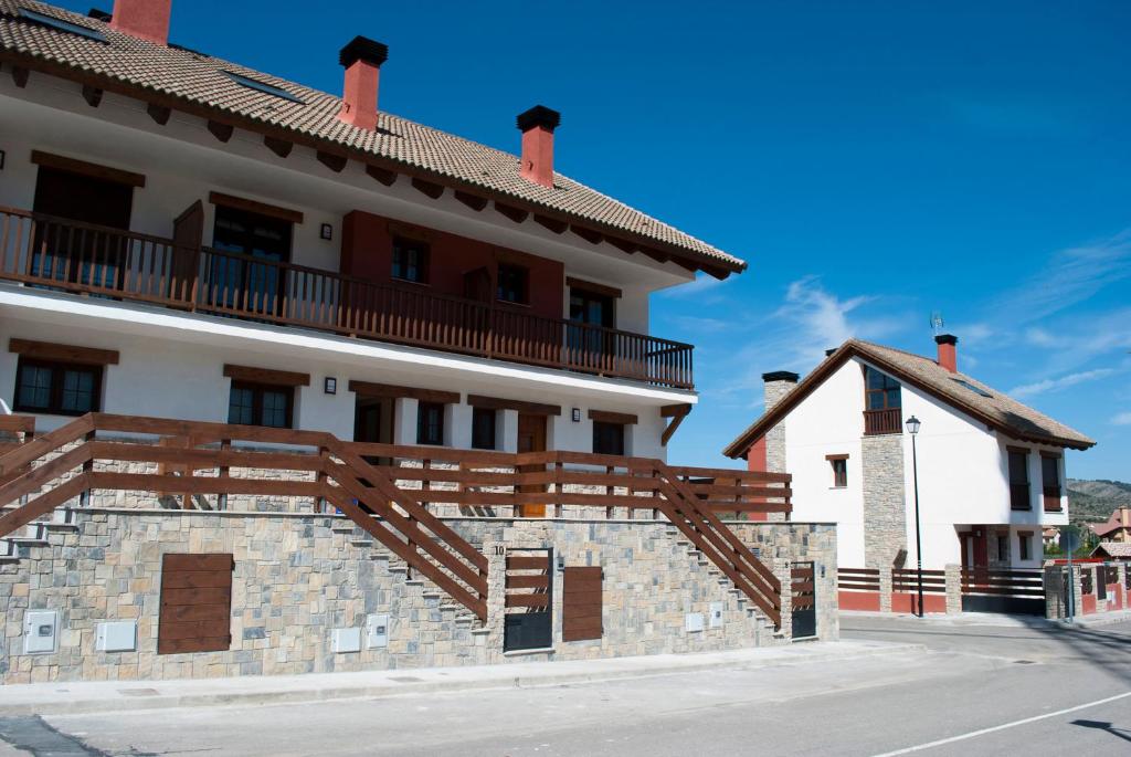 a large white building with a wooden stairway at Residencial Massana in Alcalá de la Selva