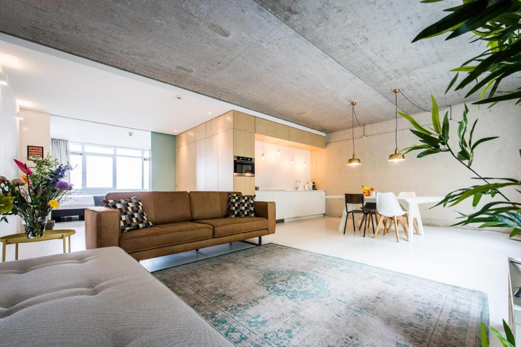 een open woonkamer met een bank en een tafel bij Houthavens Apartments in Amsterdam