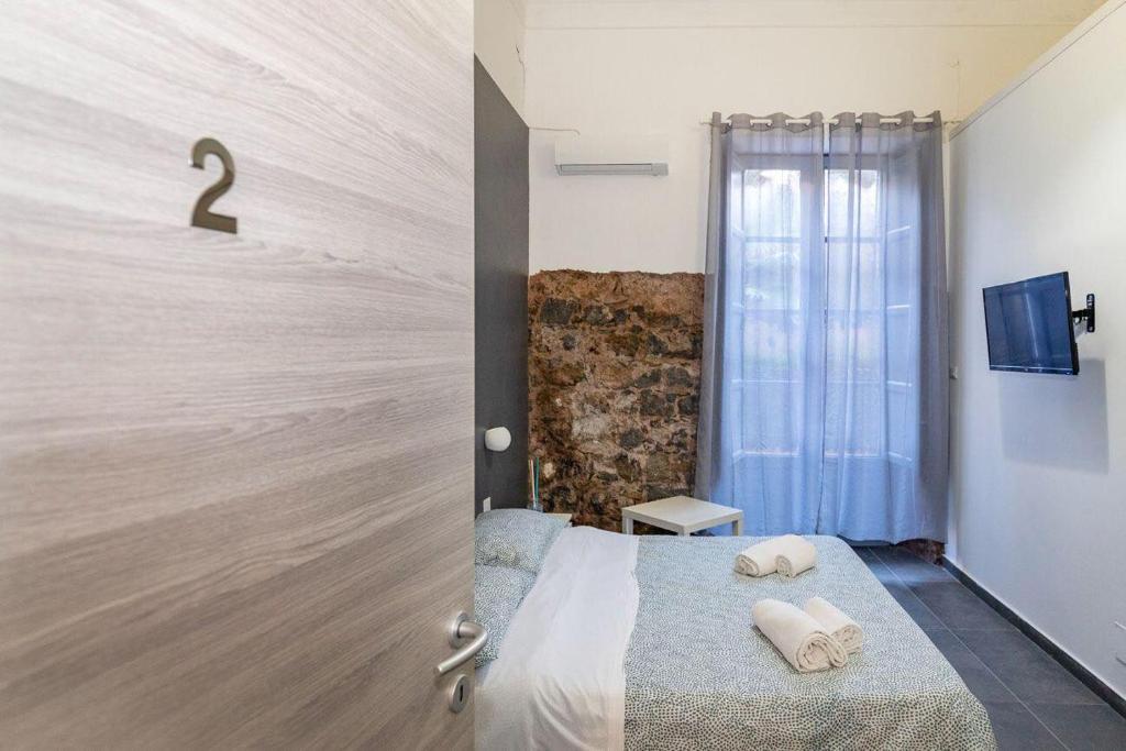 1 dormitorio con 1 cama con 2 toallas en B&B Verga, en Catania
