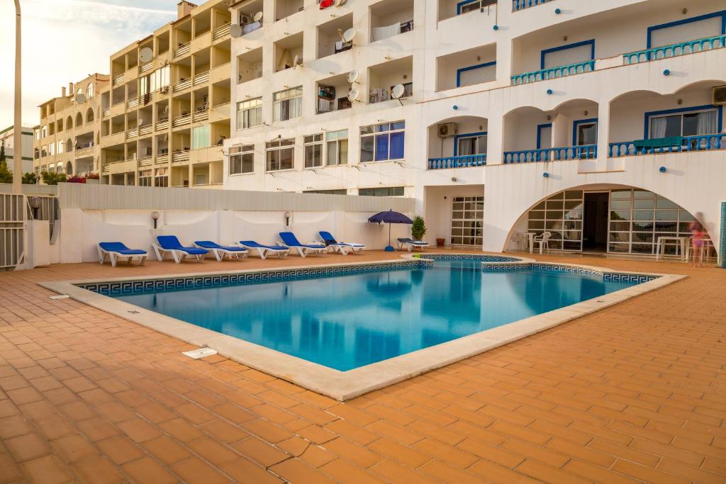 una piscina di fronte a un edificio di cantinho do mar ad Albufeira