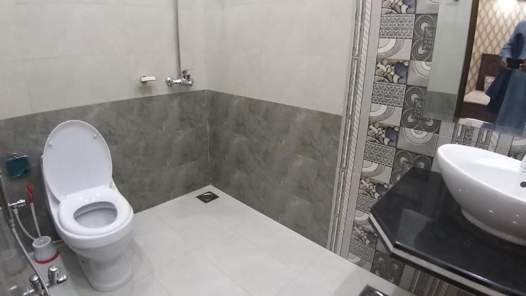 a bathroom with a toilet and a sink at Family Rooms in Johar Town in Lahore
