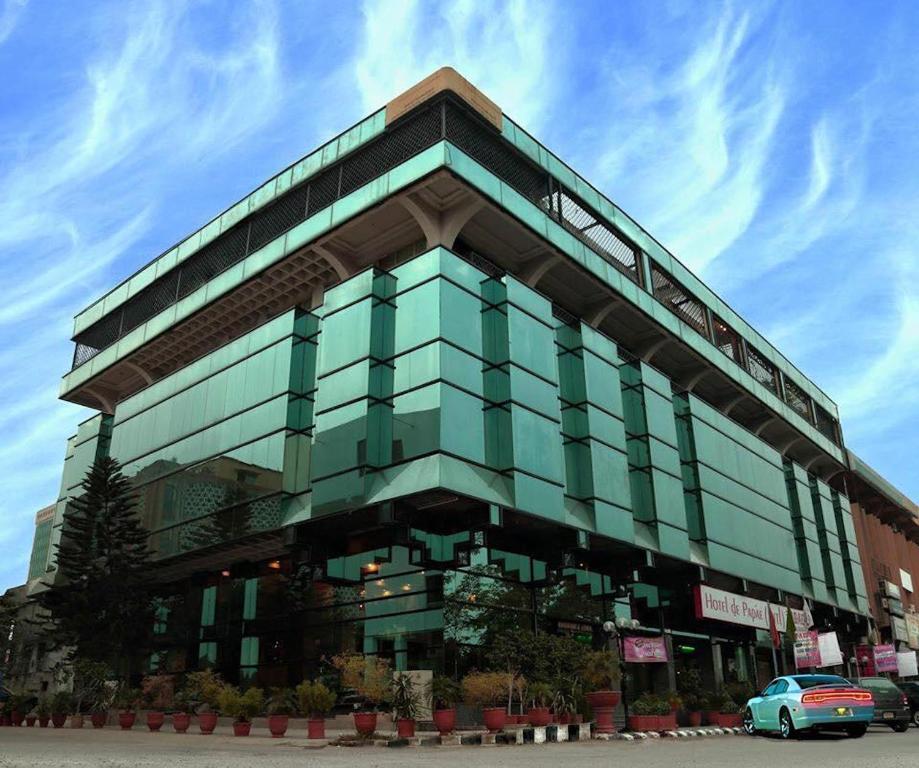 a large glass building with a car in front of it at Hotel de Papae in Islamabad