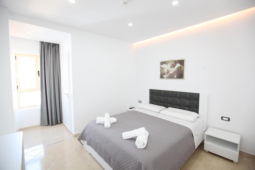 een slaapkamer met een bed met twee handdoeken erop bij Nika Hotel in Sarandë