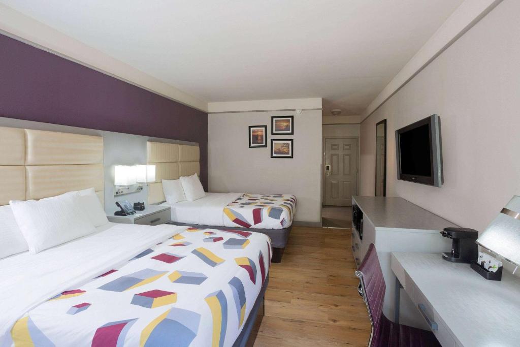 a hotel room with two beds and a flat screen tv at La Quinta by Wyndham Mobile - Daphne in Daphne