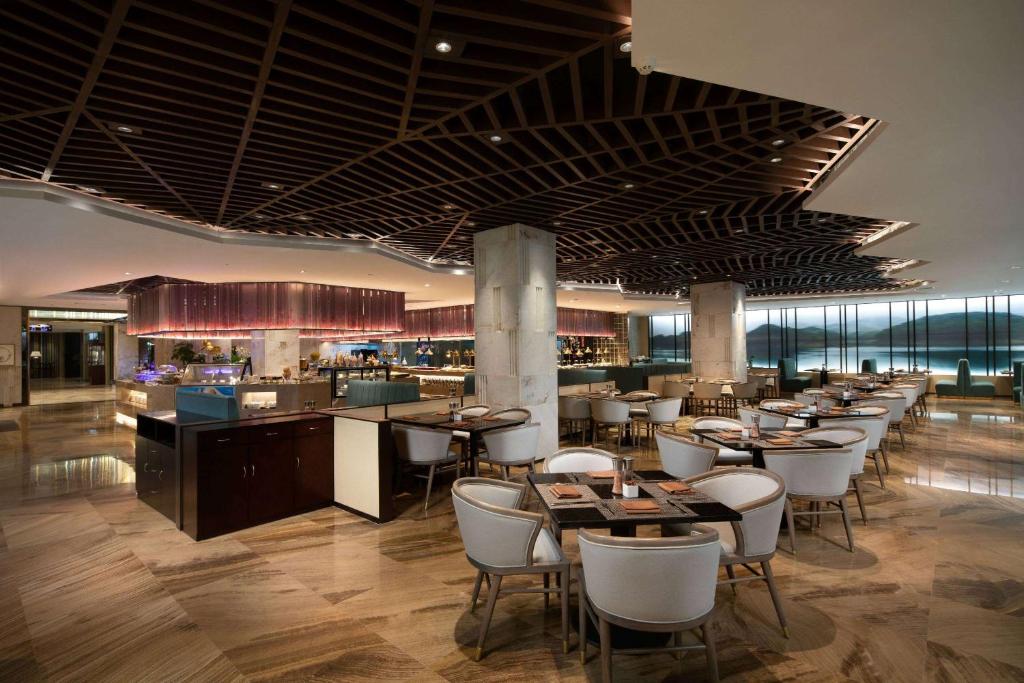 a restaurant with tables and chairs and a bar at Ramada by Wyndham Xian Long march in Jixian