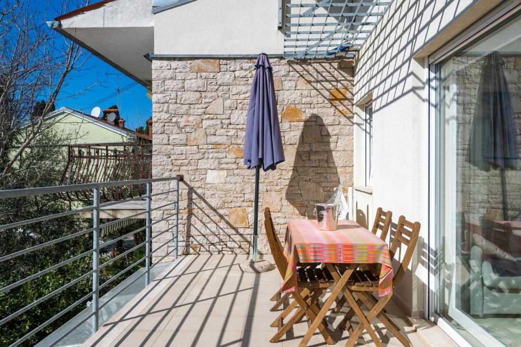 patio ze stołem i parasolem w obiekcie Apartment Manto Free Parking w Rovinj
