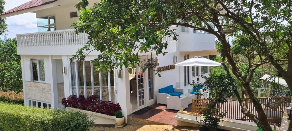 Una casa blanca con un árbol delante. en Villa Marbelice en Bandung