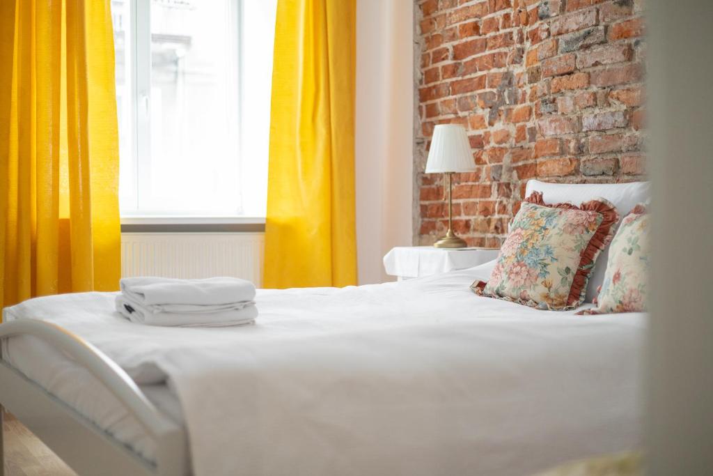 een slaapkamer met een wit bed en een geel gordijn bij Metro Politechnika Vintage Apartment in Warschau