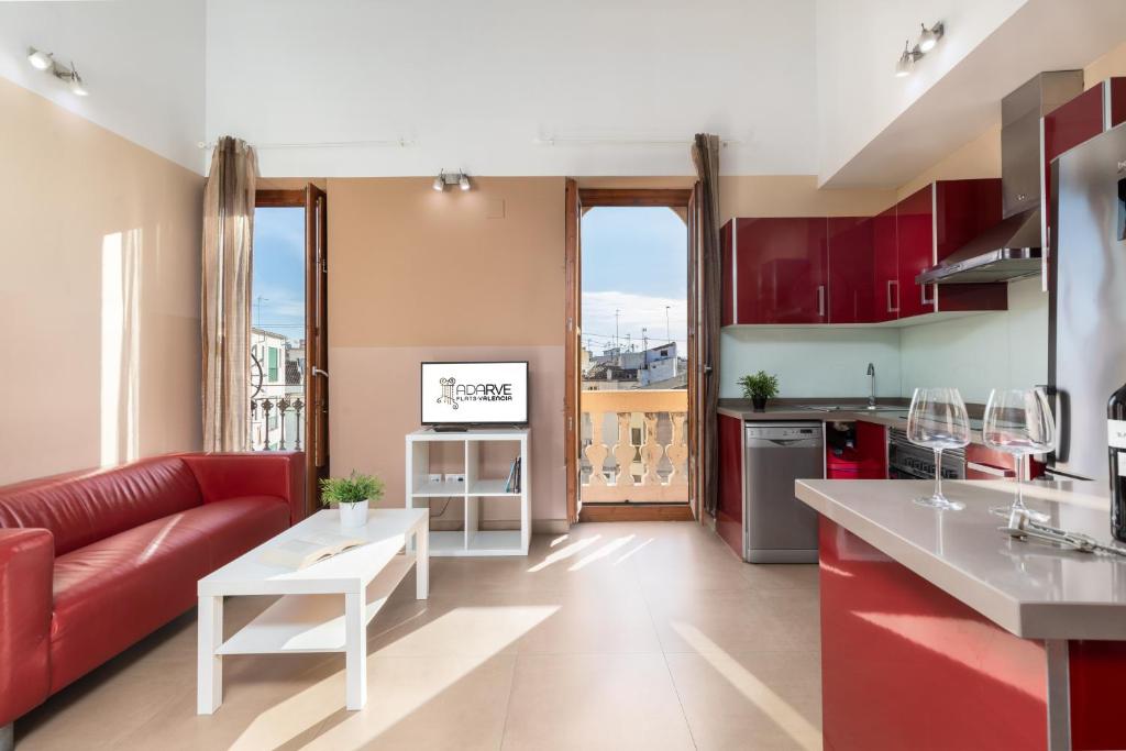 cocina y sala de estar con sofá rojo en Adarve Flats, en Valencia