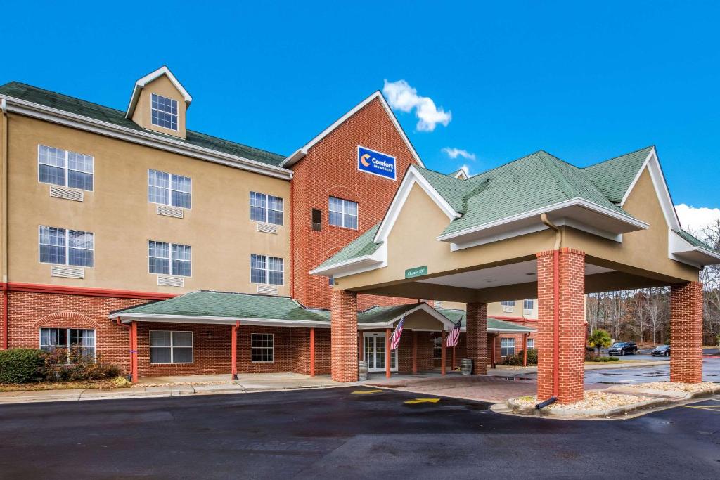 a hotel with a building with a parking lot at Comfort Inn & Suites in Fairburn