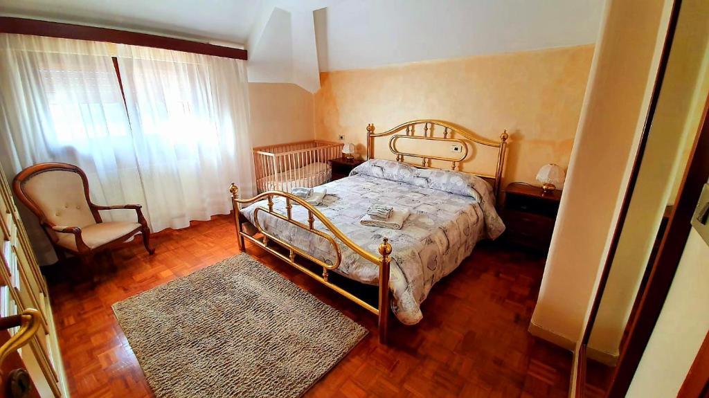 1 dormitorio con 1 cama y 1 silla en La casa di Loryanne, en Avezzano