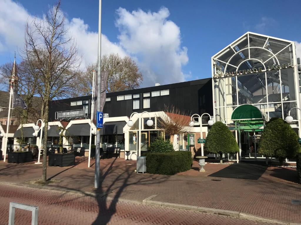 ein großes schwarzweißes Gebäude auf einer Straße in der Unterkunft Hotel De Rustende Jager in Nieuw-Vennep
