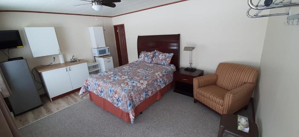 a bedroom with a bed and a chair at Super Nights Inn in Sault Ste. Marie