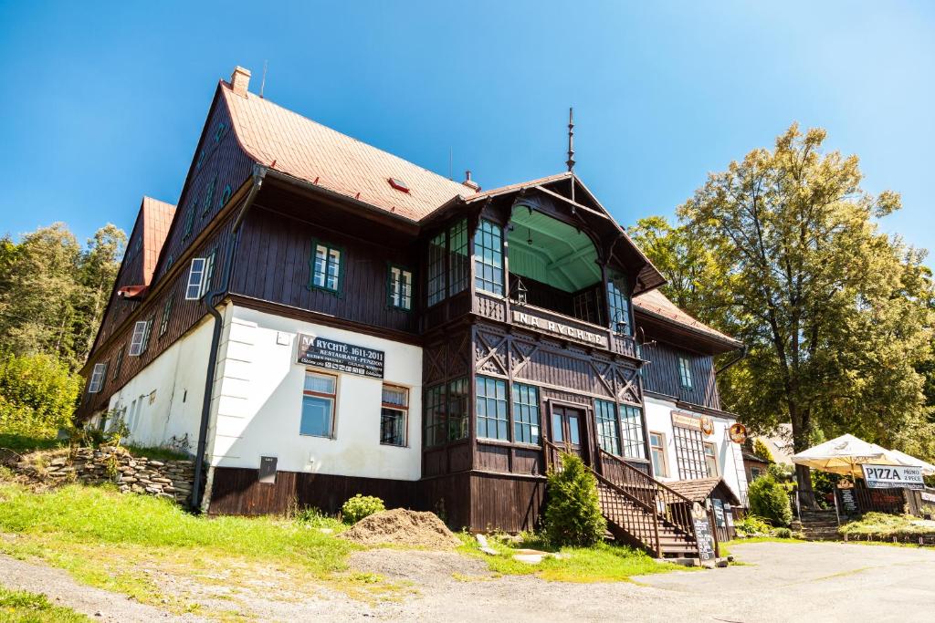 a large wooden house on top of a hill at Penzion Na Rychtě in Malá Morávka