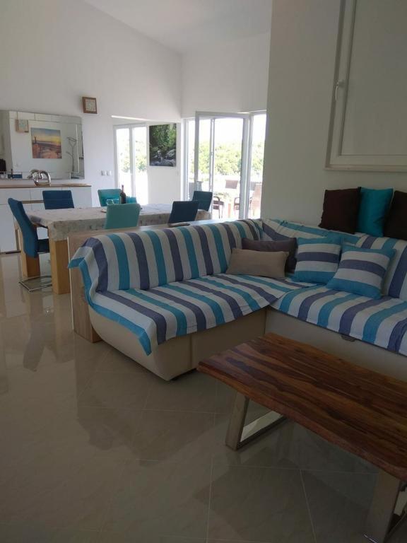 a living room with two couches and a wooden bench at Amphora Deluxe in Vrboska