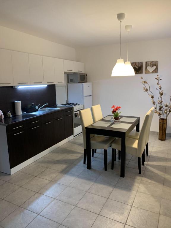 a kitchen and dining room with a table and chairs at Várlak Apartman in Dinnyés