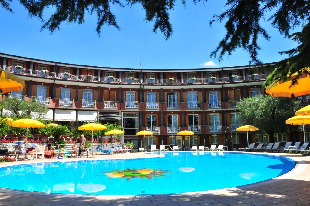 a large swimming pool in front of a building at Hotel Continental in Garda