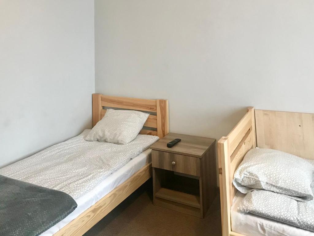 Habitación pequeña con 2 camas y una mesita de noche en Noclegi Jachtklub Elbląg en Elblag