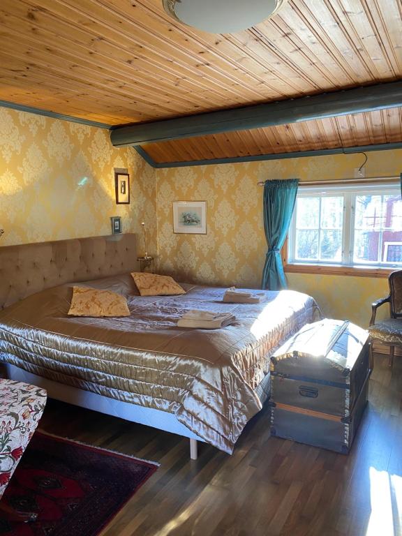 a bedroom with two beds and a wooden ceiling at Olsbacka cottage in Falun