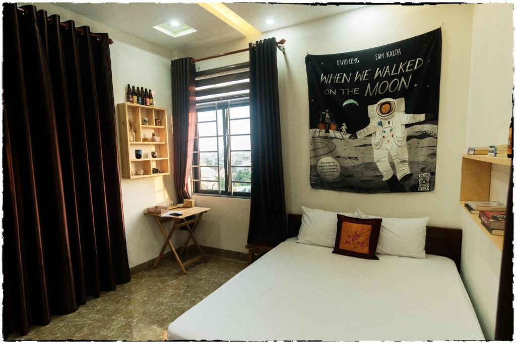 a bedroom with a bed and a poster on the wall at Nhà của Elly in Da Nang
