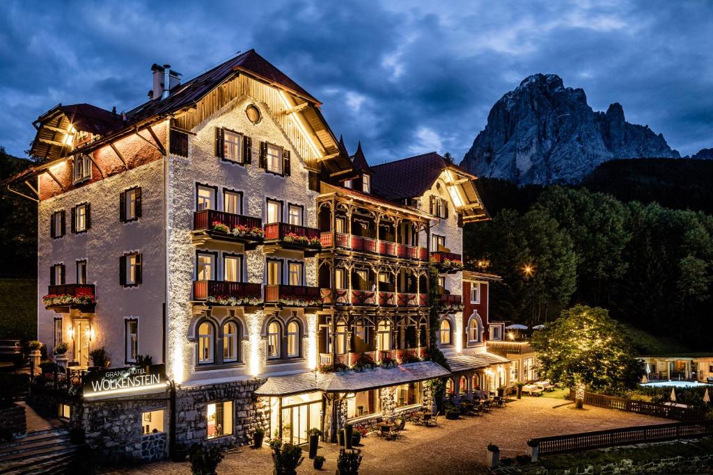 セルヴァ・ディ・ヴァル・ガルデーナにあるGrand Hotel Wolkensteinの山を背景にしたホテル
