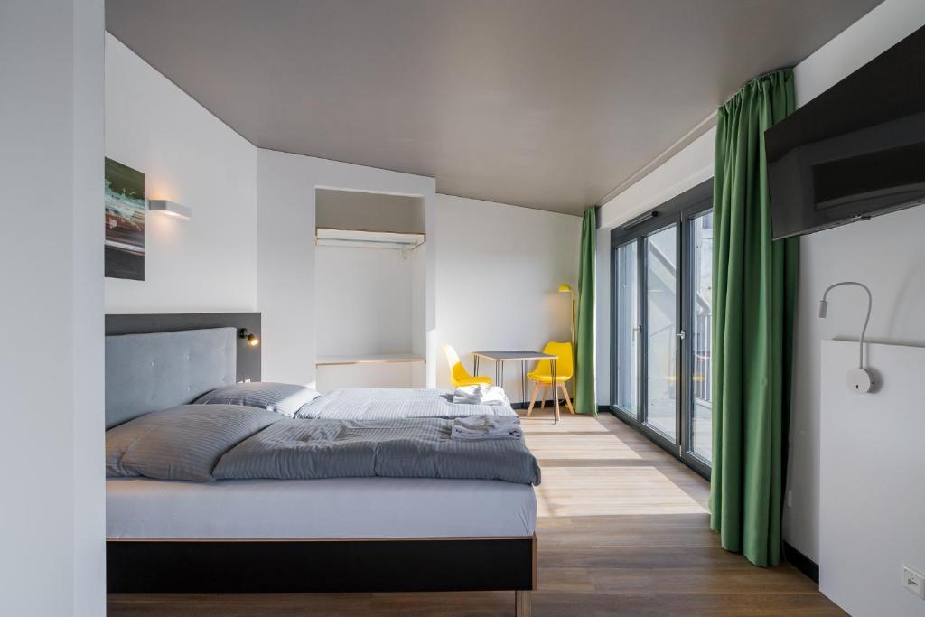 a bedroom with a bed and a large window at Nena Apartments - Kreuzberg 61 in Berlin