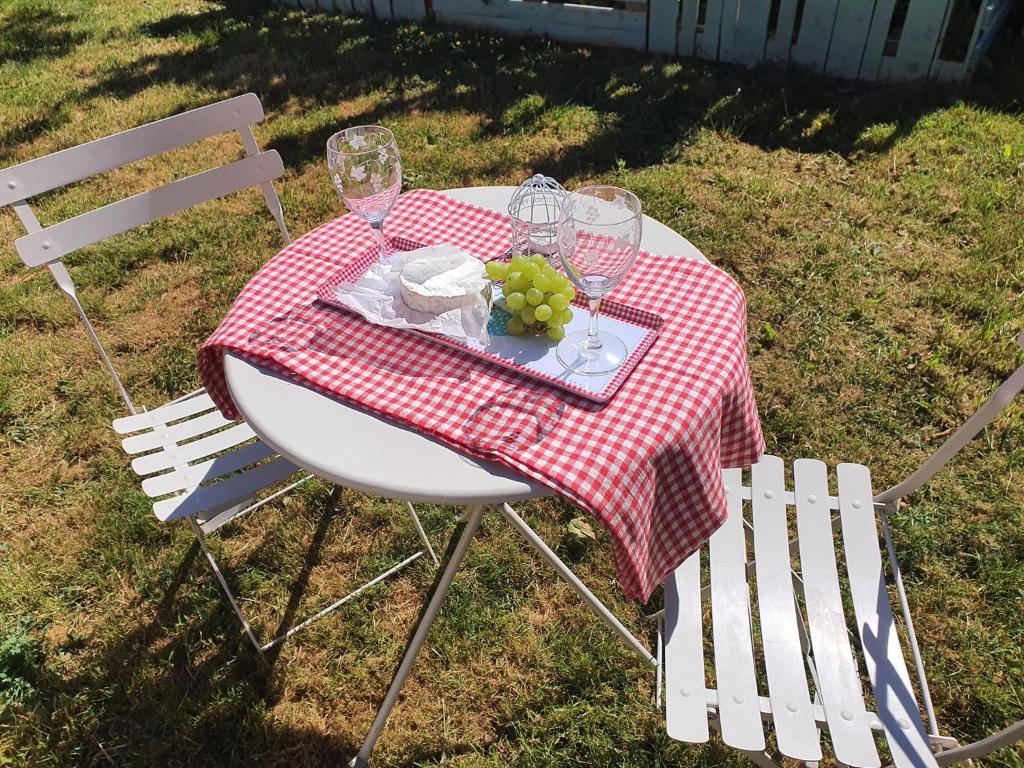 una mesa de picnic con copas de vino y uvas. en Koppány Pines Rewild Escapes - The Lodge en Koppányszántó