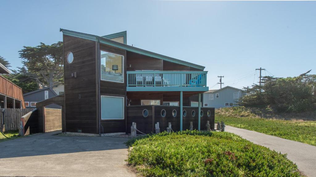 a house with a balcony on a driveway at Knot-a-Care! Hot Tub!! Walk to Beach!! BBQ! Fast WiFi!! in Dillon Beach