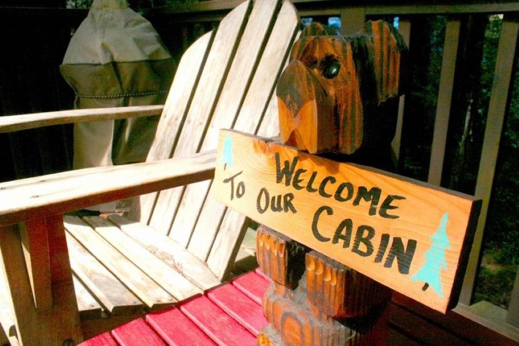 un benvenuto al cartello della nostra cabina su una panchina di Little Red House! Redwoods! Hot Tub! BBQ! Fast WiFi!! Multiple Decks!! Near Golf Course!! Dog Friendly! a Guerneville