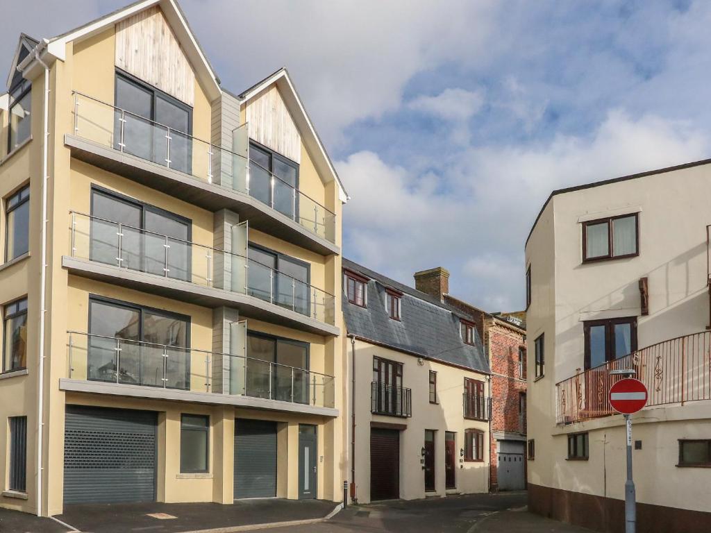 an apartment building with a balcony on a street at Harbourside Haven Penthouse 1 in Weymouth