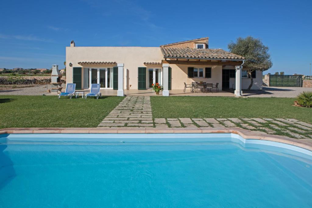 une villa avec une piscine en face d'une maison dans l'établissement Son Coves Petit, à Campos