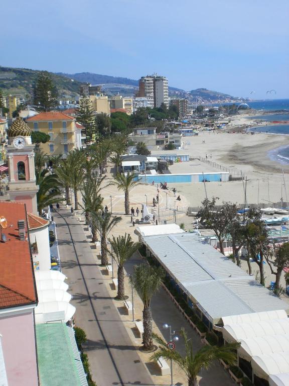 widok na plażę z palmami i budynkami w obiekcie Hotel Ideal w mieście Arma di Taggia