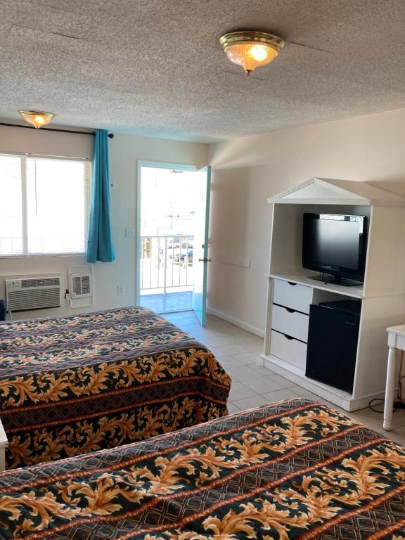 a hotel room with two beds and a flat screen tv at Surfside Motel - Seaside Heights in Seaside Heights