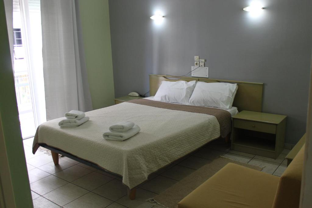 a bedroom with a bed with two towels on it at Hotel Avra in Volos