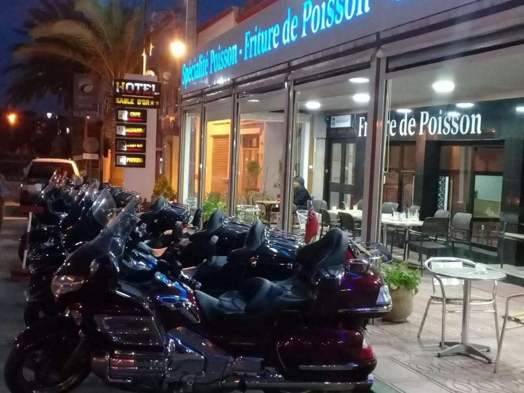 a row of motorcycles parked in front of a restaurant at Hôtel Sable d'Or in Tan-Tan