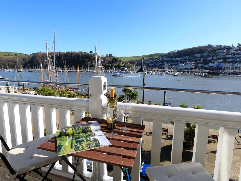 a table on a balcony with a view of the water at 2 Embankment House in Dartmouth