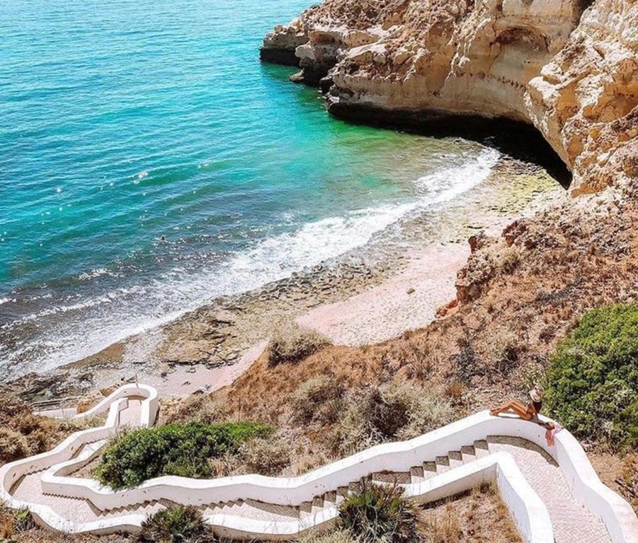 a staircase leading to a beach next to the ocean at Agua Hotels Riverside in Ferragudo