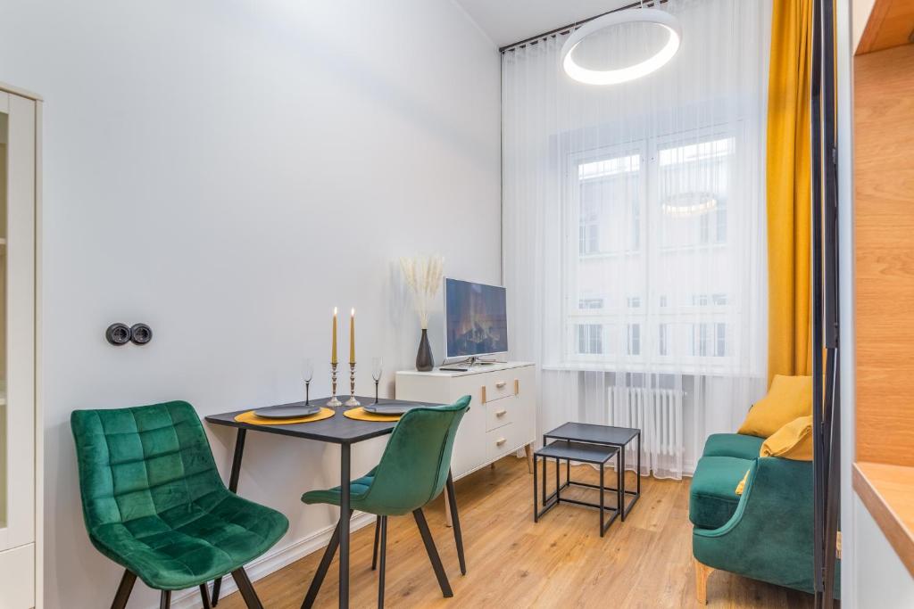 a dining room with a table and green chairs at Cosy Duo Loft - free GYM in Tartu