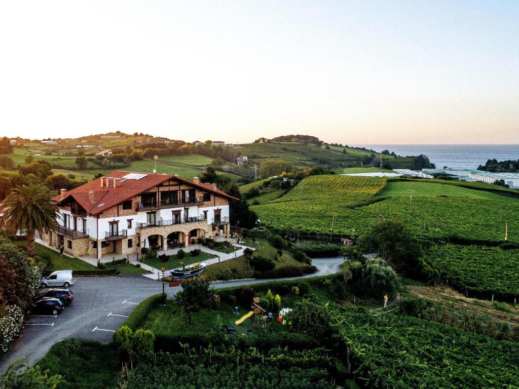 a house on a hill next to the ocean at Usotegi in Getaria