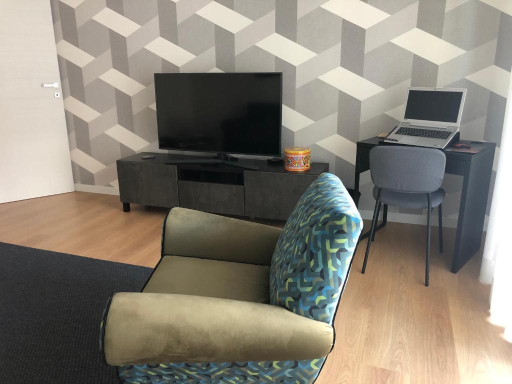 salon z kanapą, telewizorem i biurkiem w obiekcie Home 22 Appartamento in centro storico - Catania w Katanii