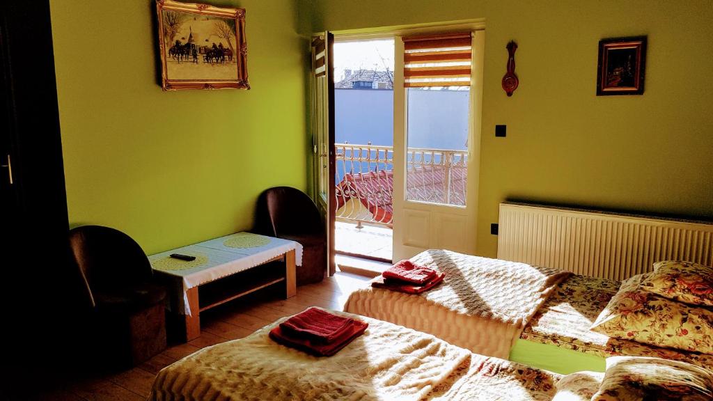 a room with two beds and a door to a balcony at Dom Gościnny Wisteria in Andrychów