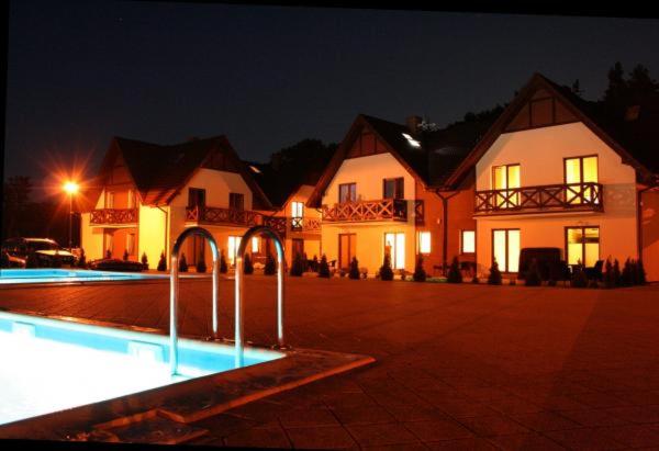 a large house with a pool in front of it at night at Apartament Łeba in Żarnowska