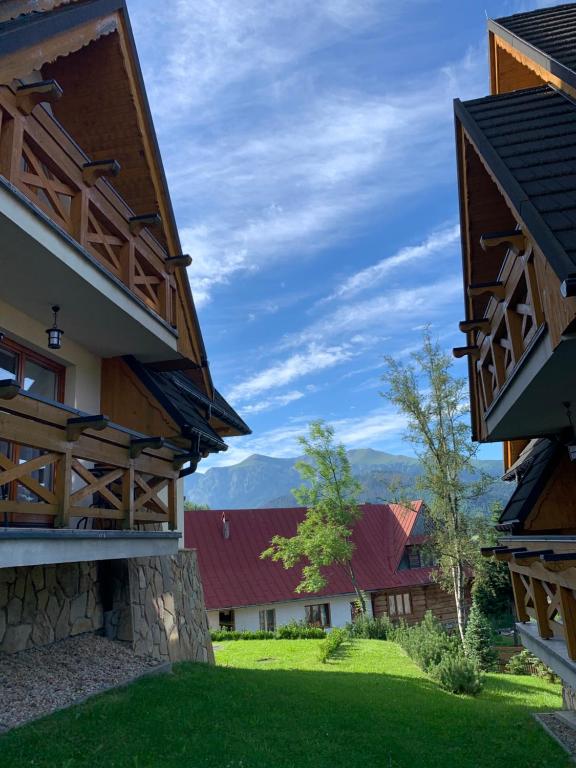 a view of the courtyard of a house with mountains in the background at Apartamenty Tomalówka Koscielisko in Kościelisko