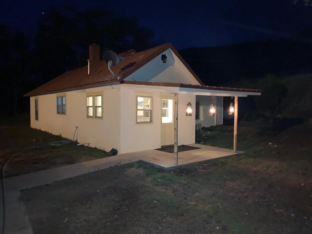 mały biały dom w nocy z światłami w obiekcie Valentine's Northern New Mexico Mountain Ranch on Colorado Border retreat w mieście Raton